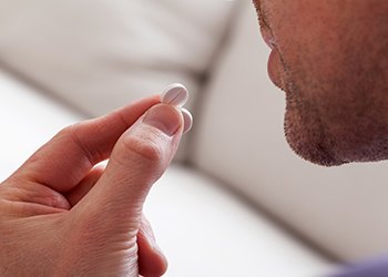 Patient preparing to take oral sedative pill