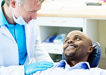 Man in dental chair smiling at dentist