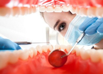 A woman performing a dental exam.