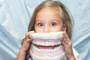 girl holding fake teeth